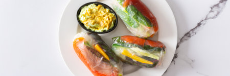 Enjoy Vietnamese spring rolls with rice paper, fresh lettuce, salmon, carrots, cucumber, and fish sauce, blending Asian and Thai cuisine for a delicious, healthy appetizer bannerの写真素材