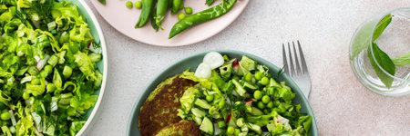 Enjoy zucchini and broccoli pancakes paired with a fresh mixed salad featuring cucumbers, young peas, and radishes. A delicious and healthy vegetarian meal , bannerの写真素材