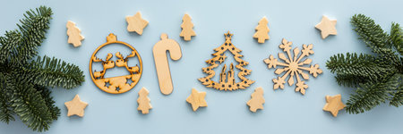 Natural wooden Christmas toys and spruce branches on a blue background, Merry Christmas and Happy New Year banner, top view, copy spaceの写真素材