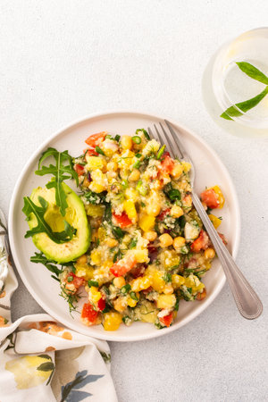 Enjoy a nutritious salad of boiled millet, chickpeas, fresh vegetables, and avocado, topped with olive oil, perfect for a wholesome vegetarian diet rich in vitamins and mineralsの写真素材