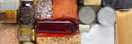 Home food supplies for quarantine and isolation, including canned food, cereals pasta and essential staples for survival, survival during military operations, the concept of stay at home, bannerの写真素材