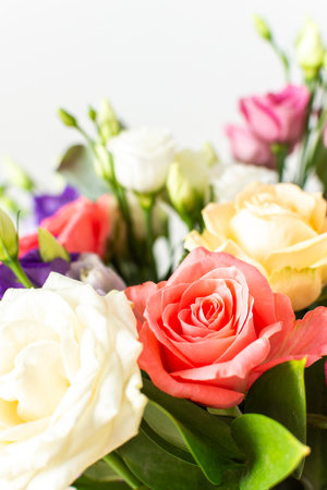 A beautiful bouquet of vibrant roses, eucalyptus, and delicate eustoma in white, pink, and purple hues, perfect for an anniversary or birthday celebrationの写真素材