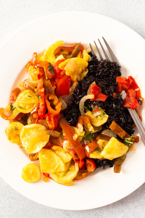 This wholesome breakfast includes black rice with stewed vegetables, with stewed tomatoes, zucchini, peppers and onionsの写真素材