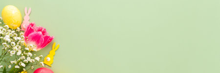 Spring Easter background, multi-colored Easter eggs with tulips and gypsophila and decorative bunnies on a green background, bannerの写真素材