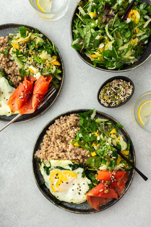 Delicious healthy breakfasts, green buckwheat with fried egg and spinach and red salmon fish, mix salad with fresh herbs and peppers and seeds, healthy balanced breakfast with fats, fiber and proteinの写真素材