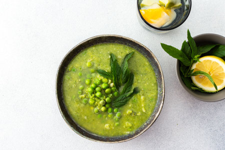 Creamy broccoli and green pea soup with mint, delicious healthy lunchの写真素材