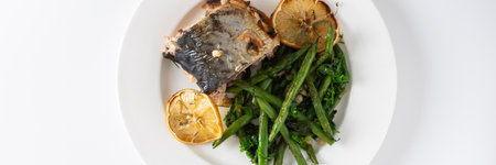 Enjoy a delicious and nutritious meal of baked green beans with onions and baked mackerel, beautifully presented on a plate against a white background, perfect for dinner, bannerの写真素材