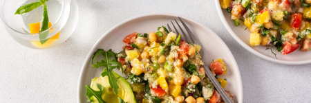 A vibrant vegetarian salad featuring boiled millet, chickpeas, fresh vegetables, and avocado, drizzled with olive oil for a delicious and healthy meal, bannerの写真素材
