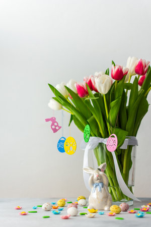 Happy Easter concept, beautiful spring bouquet of pink and white tulips and bunny looking for Easter eggsの写真素材