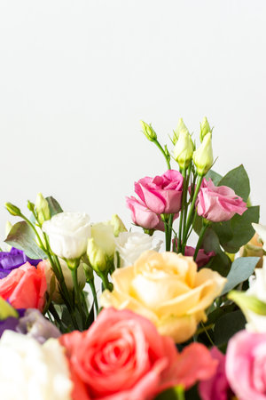 A beautiful bouquet of vibrant roses, eucalyptus, and delicate eustoma in white, pink, and purple hues, perfect for an anniversary or birthday celebrationの写真素材