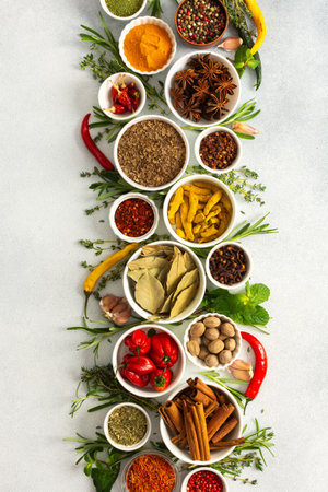 A beautiful display of cooking spices and dried herbs on a gray background, offering a palette of natural huesの写真素材