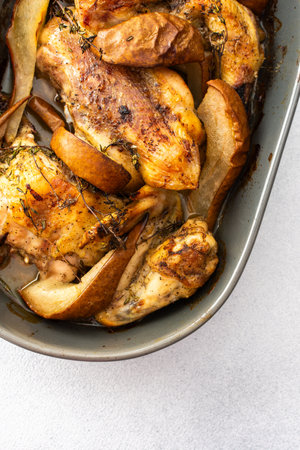 Baked chicken with pears and thyme, oval dish with baked chicken partsの写真素材