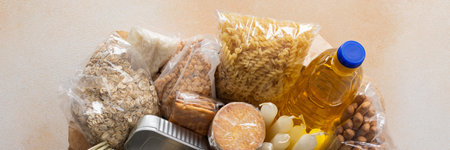 Essential home food stock for military operations and crises and for the period of quarantine and isolation, canned food and pasta, flour and nonperishable items,the concept of stay at home, bannerの写真素材