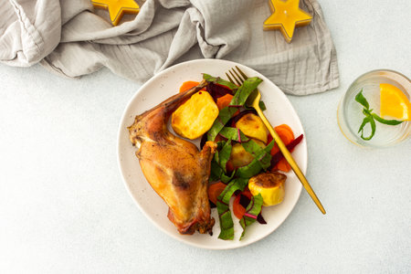 Indulge in a flavorful feast with tender baked meat, crispy potatoes, and vibrant carrot salad, creating a balanced, gourmet meal perfect for any festive occasionの写真素材