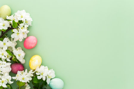 Spring Easter background, multi-colored Easter eggs and blooming apple tree branches on a green background, copy spaceの写真素材