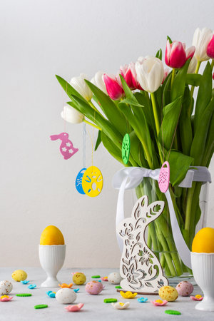 Happy Easter concept, beautiful spring bouquet of pink and white tulips and bunny looking for Easter eggsの写真素材