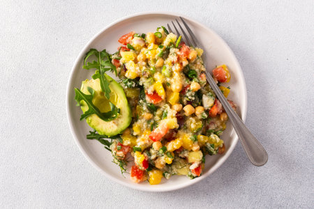 Enjoy a nutritious salad of boiled millet, chickpeas, fresh vegetables, and avocado, topped with olive oil, perfect for a wholesome vegetarian diet rich in vitamins and mineralsの写真素材