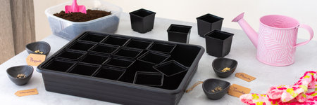 Preparation for spring work in the garden, planting tomato and pepper seeds on seedlings at home, table with plastic containers for seedlings, bannerの写真素材