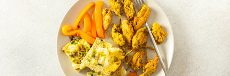 This flavorful meal includes fried zucchini flowers in golden batter, a tender cauliflower omelette with stewed peppers ideal for a healthy diet, bannerの写真素材
