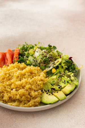 Delicious healthy breakfasts, bulgur porridge with red salmon fish and a salad mix with fresh vegetables, avocado and various seeds, a healthy balanced breakfast with fats, fiber and proteinの写真素材