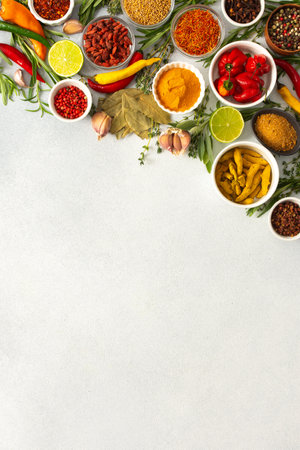 Colorful herbs and spices scattered across a gray surface, ideal for creating authentic and flavorful dishes, top view ,copy spaceの写真素材