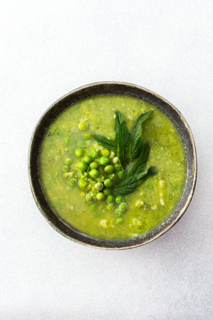 Creamy broccoli and green pea soup with mint, delicious healthy lunchの写真素材
