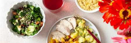 A wholesome dish featuring boiled potatoes, baked vegetables, chicken breast, and a vibrant salad with seeds, finished with a sweet and refreshing raspberry compote, bannerの写真素材