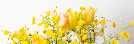 Spring bouquet of yellow buttercups banner, white daffodils and tulips, bouquet of flowers close up, home decoration with flowersの写真素材