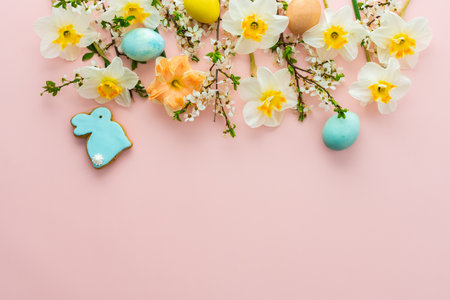 Festive background with spring flowers and naturally colored eggs and Easter bunnies on a pink pastel backgroundの写真素材