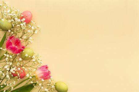 Spring Easter background, multi-colored Easter eggs with tulips and gypsophila on a yellow backgroundの写真素材