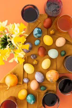 The process of dyeing Easter eggs with natural dyes, hibiscus and turmeric, onion peel and red cabbage, beetroot juice, paint containers and colored eggs on a napkinの写真素材