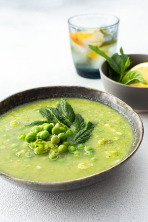 Creamy broccoli and green pea soup with mint, delicious healthy lunchの写真素材