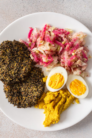 A hearty, healthy, and balanced breakfast with fresh cabbage and radish salad with mung bean sprouts, boiled eggs, hummus, and cooked beets, offering a rich source of proteinの写真素材