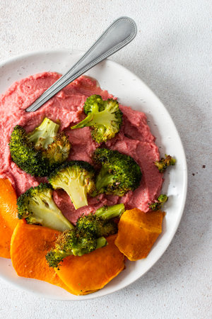 A healthy, balanced breakfast with roasted sweet potatoes and broccoliの写真素材