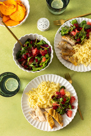A wholesome and nutritious breakfast featuring millet, baked chicken breast, a fresh salad with greens and grapefruit, and roasted sweet potatoes, perfect for a healthy startの写真素材