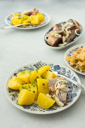 Delicious hearty fish dinners, boiled potatoes with pickled herring, sauerkraut with onionsの写真素材