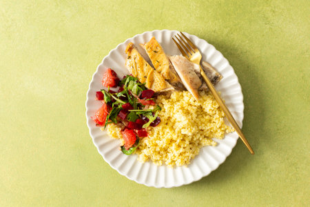 A healthy breakfast plate with millet, lean chicken breast, a citrusy salad with grapefruit, combining protein, fiber and vitamins for a nourishing startの写真素材