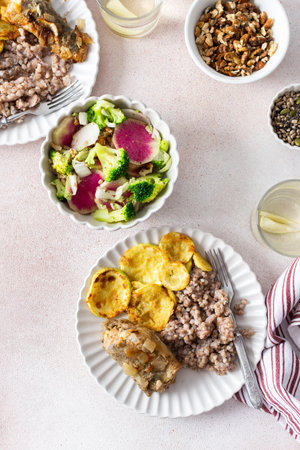 A nutritious, balanced breakfast featuring green buckwheat, fried hake, zucchini, and a fresh broccoli salad with pink radish, seeds, and nuts, offering a wholesome start to the dayの写真素材
