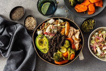 Nutritious, wholesome breakfast featuring quinoa, avocado, roast chicken, and roasted vegetables like sweet potato, zucchini, and broccoli, complemented with a fresh cabbage and radish saladの写真素材