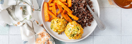 Brown rice paired with baked sweet potatoes and squash chickpea pancakes creates a hearty, healthy and flavorful dish thats both filling and nutritious, fresh salad of tomatoes and cucumbersの写真素材