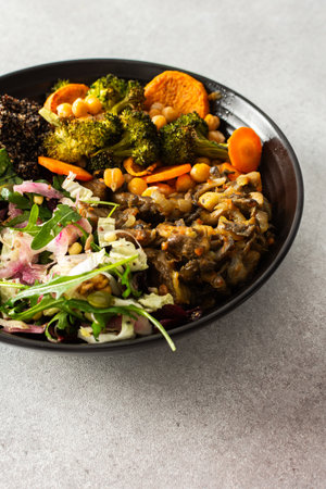 A wholesome breakfast of black quinoa, avocado, roasted vegetables like sweet potato, zucchini, and broccoli, along with a fresh salad of cabbage, radish, and chia seedsの写真素材