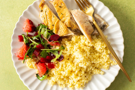 A healthy breakfast plate with millet, lean chicken breast, a citrusy salad with grapefruit, combining protein, fiber and vitamins for a nourishing startの写真素材