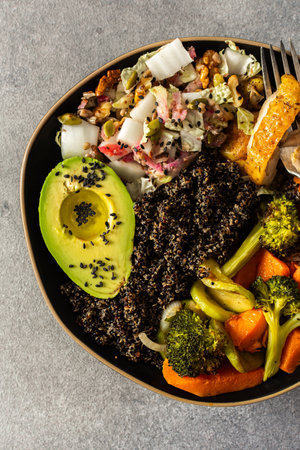 Nutritious, wholesome breakfast featuring quinoa, avocado, roast chicken, and roasted vegetables like sweet potato, zucchini, and broccoli, complemented with a fresh cabbage and radish saladの写真素材