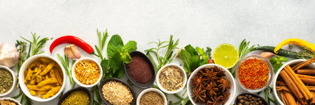 Assorted cooking spices and herbs arranged on a gray background, featuring natural tones that add depth and aroma to any meal, bannerの写真素材