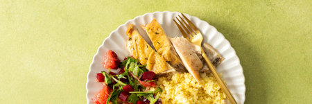 A nutritious and balanced breakfast with millet, baked chicken breast, a fresh salad with greens and grapefruit, providing protein, fiber, and vitamins for energy, bannerの写真素材