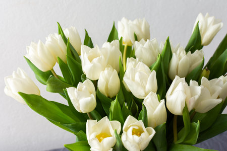 Close-up of a beautiful spring bouquet with white tulips, showcasing the delicate petals and vibrant freshness, perfect for nature-inspired decorの写真素材