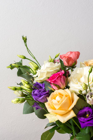 A beautiful bouquet of vibrant roses, eucalyptus, and delicate eustoma in white, pink, and purple hues, perfect for an anniversary or birthday celebrationの写真素材