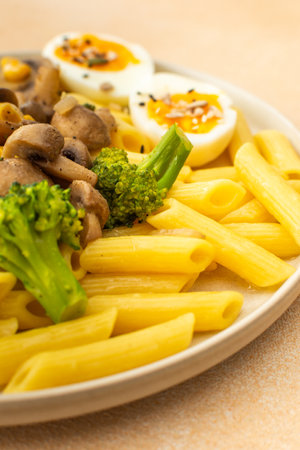 Pasta with fried mushrooms and broccoli, green peas and corn, fresh mix salad with radishes with seedsの写真素材