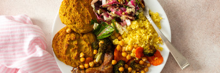 A nutritious, hearty breakfast of lentil zucchini pancakes, millet, baked chicken neck, roasted sweet potatoes, broccoli, carrots, chickpeas, with a fresh salad of radish, sprouts, and nuts, bannerの写真素材