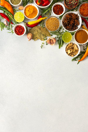 Colorful herbs and spices scattered across a gray surface, ideal for creating authentic and flavorful dishes, top view ,copy spaceの写真素材